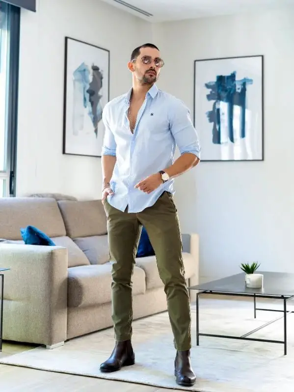 Calm Thoughtful Handsome Dark-haired Guy Wearing Blue Shirt and Beige Pants,  Standing Against Blue Wall Stock Photo - Image of background, blue:  138679362