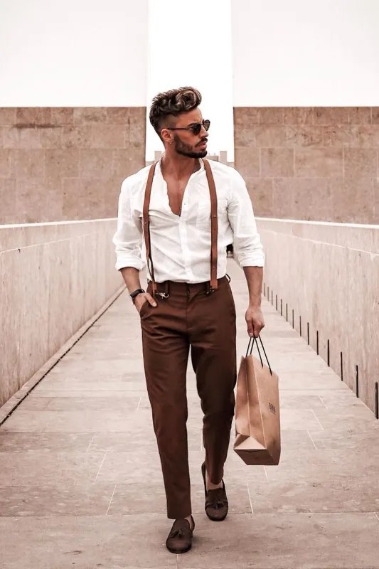 a young man wearing a white shirt and brown pants Stock Photo by Icons8