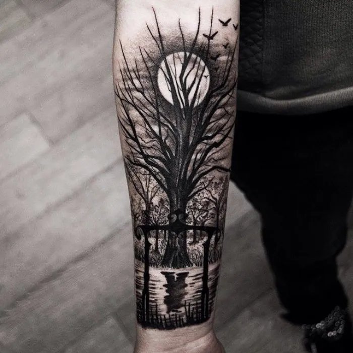 Dark tree and moon scene tattoo design on hand