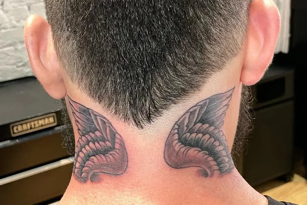 Wing design tattoo on neck 