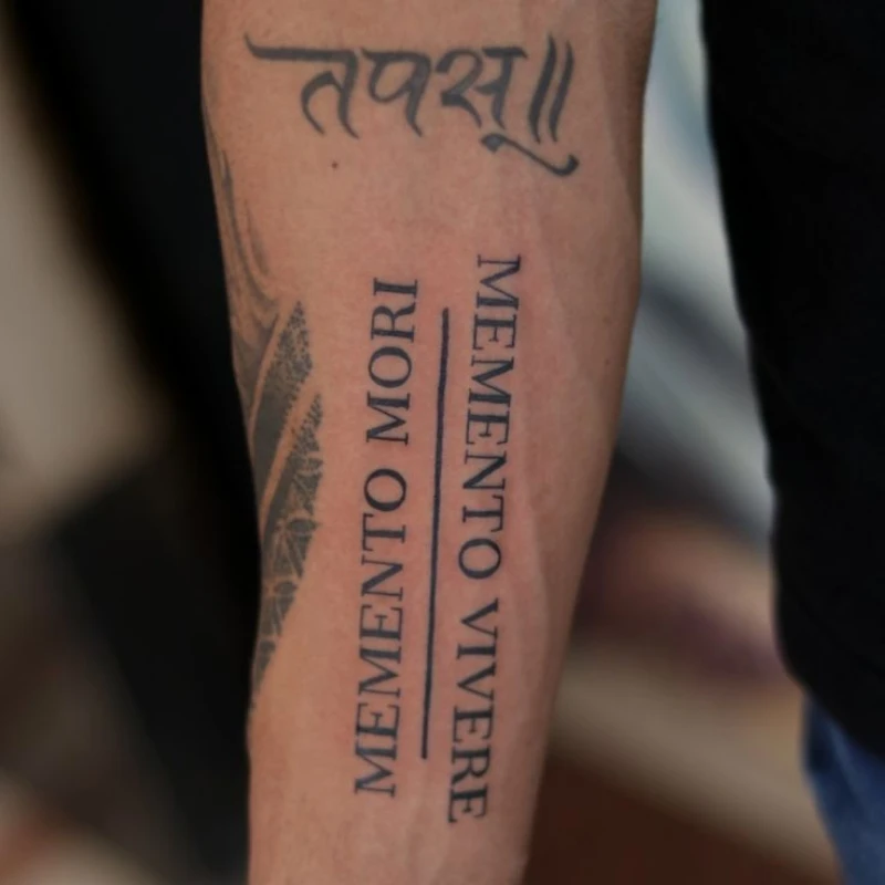 Text tattoo on hand - memento mori memento vivere