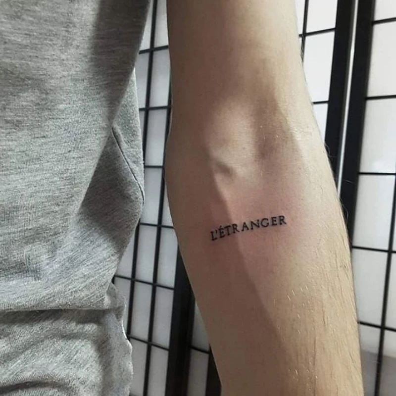 Small text tattoo on hand - l'etranger