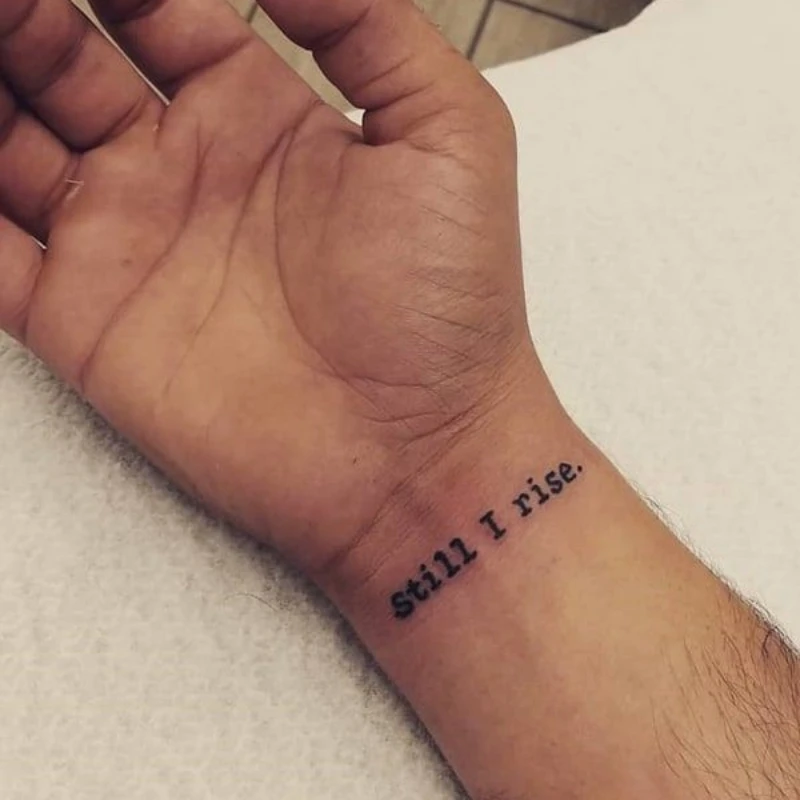 Small text tattoo on hand men - still I rise