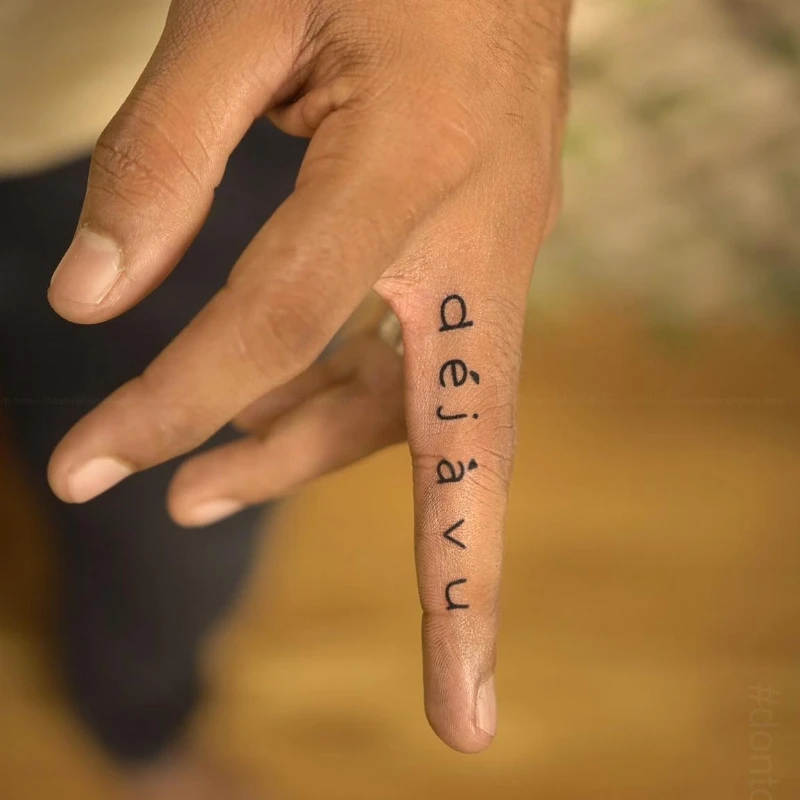 Text tattoo on finger men - dejavu
